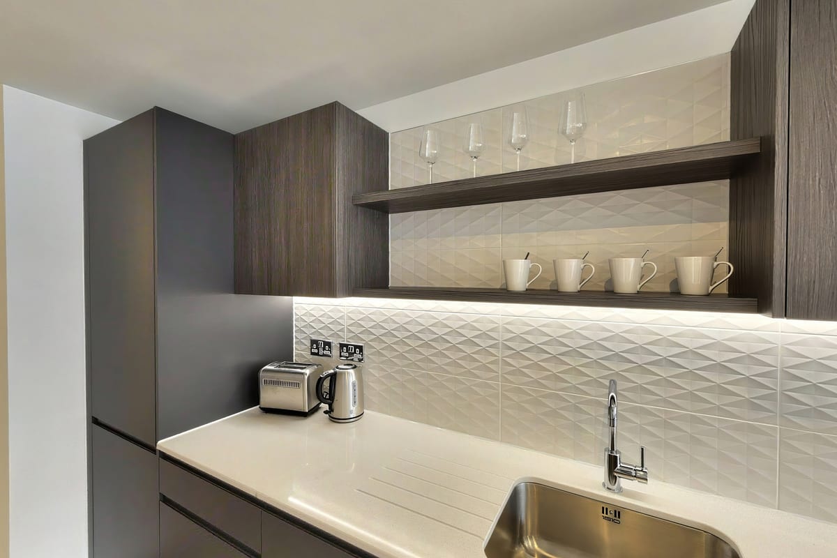 Walnut kitchen with open shelving, a textured white splashback and a stainless steel sink
