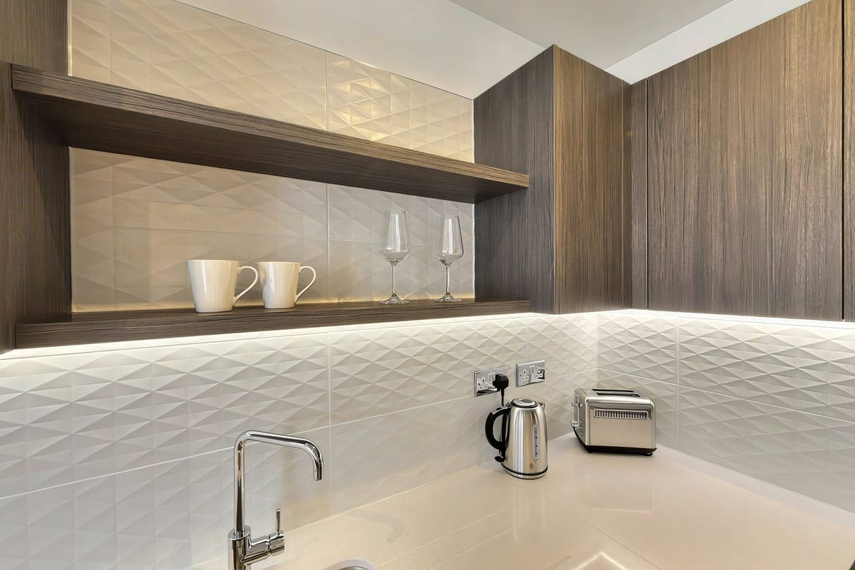 Walnut kitchen with a white textured tile splashback and under-cabinet lighting