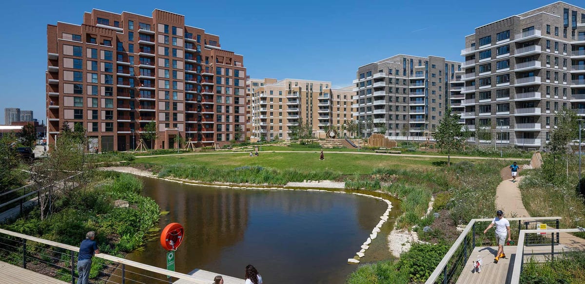 The lake in Garden Square, Lombard Square, with boardwalks and wildflower planting in front of the red-brick and grey apartment buildings