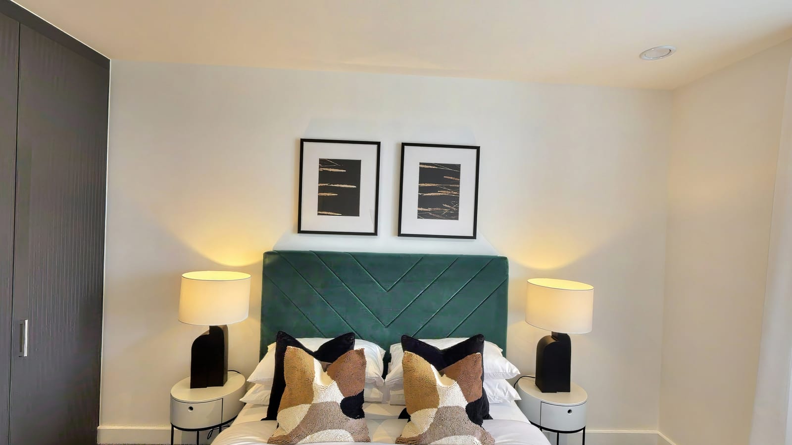Bedroom in Rosa House apartment 4.1-07-07 with a teal velvet headboard between two lamps